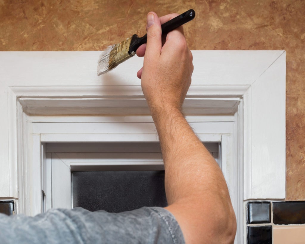 Man painting white window frame