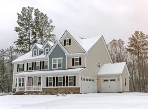 Large home with off-white siding covered with snow